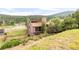 Secluded home featuring mature trees, multi-car garage, and a stone chimney at 3260 Bit Rd, Evergreen, CO 80439