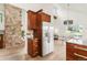 Kitchen with stainless steel refrigerator, stone wall, and dining area beyond at 3260 Bit Rd, Evergreen, CO 80439