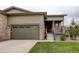 Home exterior with a two-car garage, stone accents, and inviting front porch and well-manicured lawn at 7029 Sagerock St, Castle Pines, CO 80108