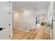 Bright hallway showcasing wood floors and an open floor plan connecting to living spaces at 7029 Sagerock St, Castle Pines, CO 80108