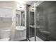 Modern bathroom featuring a gray tiled shower, white vanity with storage and a round mirror at 1169 S Reed Way, Lakewood, CO 80232