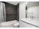 Modern bathroom with dark tile shower, white vanity, and stylish fixtures at 1169 S Reed Way, Lakewood, CO 80232