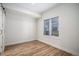 Bright bedroom featuring wood-look flooring, sliding doors and a sunlit window with blinds at 1169 S Reed Way, Lakewood, CO 80232