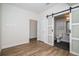 Bright bedroom featuring wood-look flooring, sliding doors to bathroom, closet and door to hall at 1169 S Reed Way, Lakewood, CO 80232