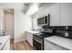 Modern kitchen with stainless steel appliances, white cabinetry, stone countertops, and black backsplash at 1169 S Reed Way, Lakewood, CO 80232