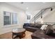 Stylish living room featuring a large leather sectional, hardwood floors, and modern staircase at 1169 S Reed Way, Lakewood, CO 80232