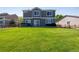 Backyard showcasing the home, spacious lawn, and a fence-lined perimeter, and hot tub at 14803 E 119Th Ave, Commerce City, CO 80603