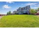 Backyard showcasing the home, spacious lawn, and a fence-lined perimeter at 14803 E 119Th Ave, Commerce City, CO 80603