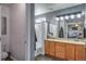 Bright bathroom featuring double sinks, a tub with shower, and modern lighting at 14803 E 119Th Ave, Commerce City, CO 80603