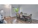 Bright dining room features wood floors, a large window, and a stylish table that seats six at 14803 E 119Th Ave, Commerce City, CO 80603