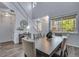 Bright dining room features wood floors, a large window, and a stylish table that seats six at 14803 E 119Th Ave, Commerce City, CO 80603