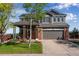 Charming two-story home with a well-manicured lawn, a two-car garage, and a welcoming front porch at 14803 E 119Th Ave, Commerce City, CO 80603