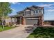 Charming two-story home with a well-manicured lawn, a two-car garage, and a welcoming front porch at 14803 E 119Th Ave, Commerce City, CO 80603