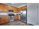 Well-equipped kitchen featuring stainless steel appliances and wood cabinetry at 14803 E 119Th Ave, Commerce City, CO 80603