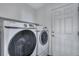 Bright laundry room features side-by-side Samsung washer and dryer and a white door at 14803 E 119Th Ave, Commerce City, CO 80603