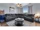 Comfortable living room with a large sectional, modern ceiling fan and a view of the outdoors at 14803 E 119Th Ave, Commerce City, CO 80603
