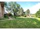 Expansive backyard featuring a well-maintained lawn, mature trees, and a charming patio area with steps at 6742 Cole Cir, Arvada, CO 80004