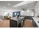 Open concept kitchen and living room with a large island, hardwood floors, and abundant lighting at 6742 Cole Cir, Arvada, CO 80004