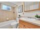 The bathroom features a tiled shower/tub, a window, and vanity with wood cabinets at 10301 Owens Cir, Broomfield, CO 80021