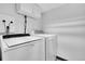 Bright laundry room showcasing modern, front-loading washer and dryer appliances for efficient chore management at 10301 Owens Cir, Broomfield, CO 80021