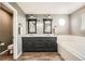 Elegant bathroom with double vanity, dark cabinets, wood-look tile, a bathtub, and modern fixtures at 4206 Eagle Ridge Way, Castle Rock, CO 80104