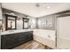 Elegant bathroom with double vanity, dark cabinets, wood-look tile, a bathtub, and a shower at 4206 Eagle Ridge Way, Castle Rock, CO 80104