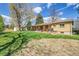 Large green backyard with mature trees and brick patio at 12286 W Tennessee, Lakewood, CO 80228