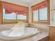 Close-up of the bathroom's soaking tub, surrounded by tile, and with windows offering scenic views at 371 Buckskin Ct, Parker, CO 80138