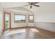 Bright living room featuring vaulted ceiling, wood floors, and large windows with scenic views and access to outdoor deck at 371 Buckskin Ct, Parker, CO 80138
