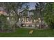 Back of house at dusk, showcasing its stone exterior and manicured backyard with cornhole game at 24556 E Ottawa Ave, Aurora, CO 80016