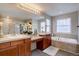 Bright bathroom features dual sinks, a soaking tub, and modern fixtures at 24556 E Ottawa Ave, Aurora, CO 80016