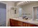 Bathroom with a double sink vanity with wood cabinets and a large mirror at 24556 E Ottawa Ave, Aurora, CO 80016