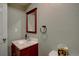 Powder room featuring a dark wood vanity cabinet and framed mirror at 24556 E Ottawa Ave, Aurora, CO 80016