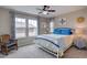 Cozy bedroom featuring a comfortable bed, rocking chair, and natural light from a window at 24556 E Ottawa Ave, Aurora, CO 80016