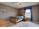 Relaxing bedroom with wood bed frame, night stand, and a window with blue curtains at 24556 E Ottawa Ave, Aurora, CO 80016