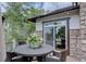 The outdoor deck has ample space for entertaining, featuring a table, chairs, decorative plants, and a sliding glass door at 24556 E Ottawa Ave, Aurora, CO 80016