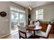 Cozy dining area with a round wood table, chairs, and sliding doors to a patio at 24556 E Ottawa Ave, Aurora, CO 80016