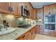 Close up on the dark wooden kitchen cabinetry, granite counter tops and stainless steel appliances at 24556 E Ottawa Ave, Aurora, CO 80016