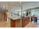 Bright kitchen featuring a spacious granite island, stainless steel dishwasher, and wood cabinets at 24556 E Ottawa Ave, Aurora, CO 80016