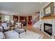 Open-concept living room showing fireplace, staircase, hardwood floors, and view of kitchen at 24556 E Ottawa Ave, Aurora, CO 80016