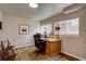 Home office with a wooden desk, natural light, and view of the backyard at 24556 E Ottawa Ave, Aurora, CO 80016