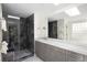 Modern bathroom with sleek gray vanity, spacious shower with glass door, and natural light at 355 Steele St, Denver, CO 80206
