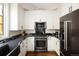 Beautiful kitchen featuring white cabinetry, stainless steel appliances, and black marble countertops at 355 Steele St, Denver, CO 80206