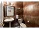 Powder room featuring decorative wallpaper, pedestal sink, mirror, and toilet at 355 Steele St, Denver, CO 80206