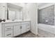 A bright bathroom features a double sink vanity, a large mirror, and a tiled shower-tub combination at 2070 Wagon Wheel Aly, Brighton, CO 80601
