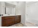 This bathroom features double sinks, dark cabinets, and a white shower-tub combo at 2070 Wagon Wheel Aly, Brighton, CO 80601