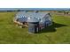 An eye-catching house boasts a large lawn, grey metal roofing, white siding and a silo-inspired entryway at 2070 Wagon Wheel Aly, Brighton, CO 80601