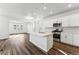 Bright, open kitchen with white cabinets, stainless steel appliances, and a large center island at 2070 Wagon Wheel Aly, Brighton, CO 80601