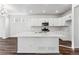 Bright kitchen featuring an island, white cabinets, and wood-look floors at 2070 Wagon Wheel Aly, Brighton, CO 80601