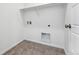 A bright laundry room with tile flooring offers a utility sink, shelving, and washer-dryer hookups at 2070 Wagon Wheel Aly, Brighton, CO 80601